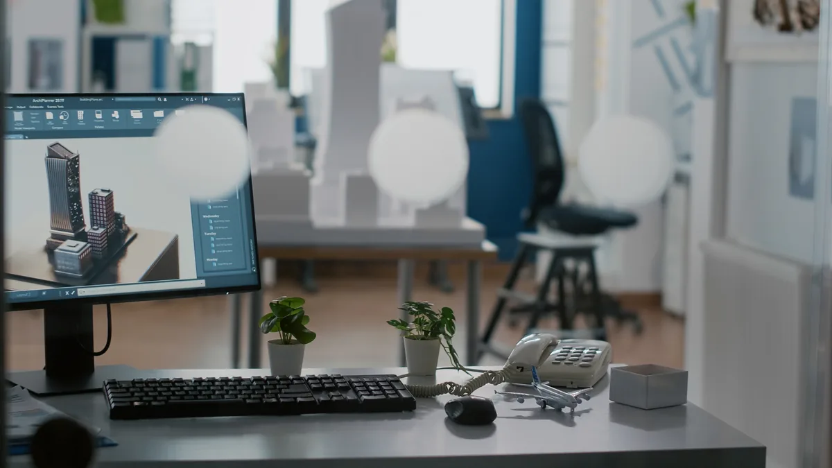 Computador para arquitetura montado ao lado da mesa de trabalho de um arquiteto com dois monitores exibindo modelo 3D e render